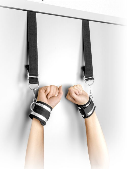Paire de menottes de suspension de porte de la marque Fetish Tentation comportant deux sangles ajustables. Les sangles sont reliées à deux barres afin de les fixer à la porte.